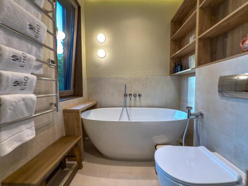a bathroom with a white tub and a toilet at Eho Resort in Ilʼtsya Gurny