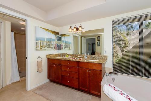 ein Badezimmer mit Badewanne und großem Spiegel in der Unterkunft Ellen`s House-pool and Jacuzzi, Gulf access in Matlacha