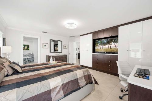 ein Schlafzimmer mit einem Bett, einem Schreibtisch und einem Fernseher in der Unterkunft Endless Summer - 4 Bedroom with Gym and Jacuzzi in Matlacha