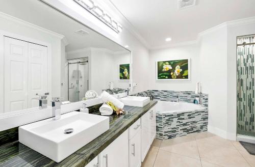 ein Badezimmer mit zwei Waschbecken und einem großen Spiegel in der Unterkunft Endless Summer - 4 Bedroom with Gym and Jacuzzi in Matlacha