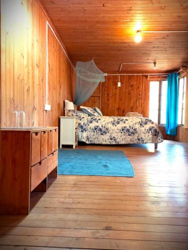 a bedroom with two beds and a blue rug at Palmera el Refugio in Olmué