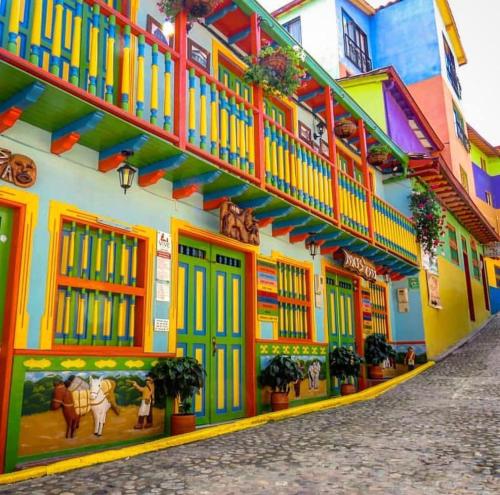 a colorful building with colorful doors and windows at HOTEL BLUE GUATAPE in Guatapé