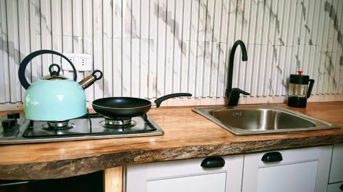 a kitchen counter with a sink and a tea kettle at Glamp Refugio Silvestre 7 Tazas in Molina