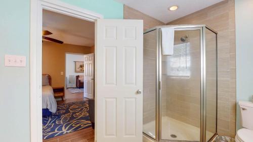 a bathroom with a shower and a glass door at Americana Beach in Jekyll Island