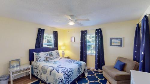 a bedroom with a bed and a chair at Americana Beach in Jekyll Island
