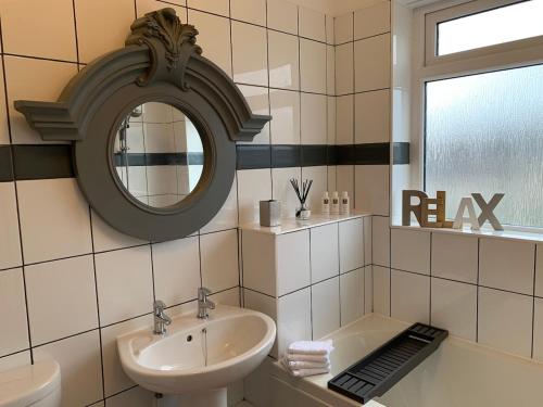 a bathroom with a sink and a mirror at The Maisonette - Central Windermere, with parking in Windermere
