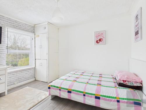 a white bedroom with a bed and a window at 3 Bed House in Reading Area in Reading