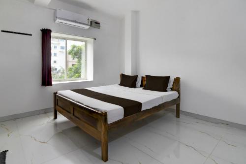 a bed in a white room with a window at Hotel O Shree Guest House in Khandagiri