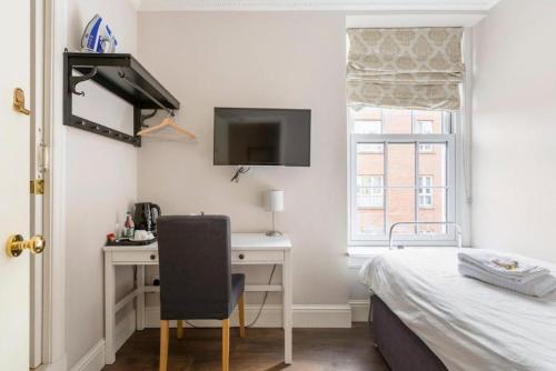 a bedroom with a bed and a desk with a computer at Molloys Apartments in Dublin