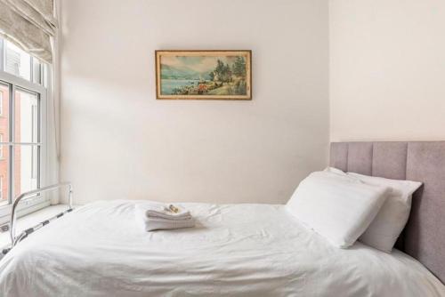 a bedroom with a white bed with a picture on the wall at Molloys Apartments in Dublin