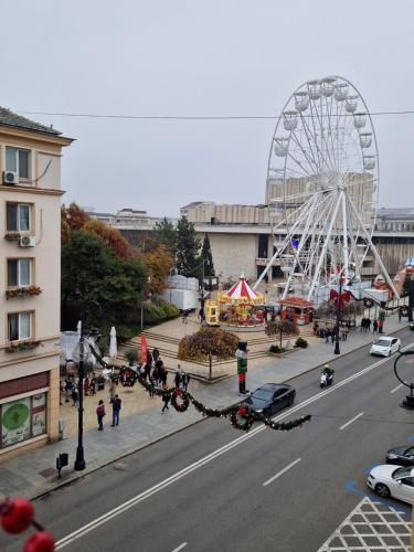 a ferris wheel in a city with a street at Cuza Residence in Craiova