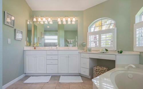 ein Badezimmer mit Badewanne und großem Spiegel in der Unterkunft Flip & Flops - Amazing location with Boating Acces in Matlacha