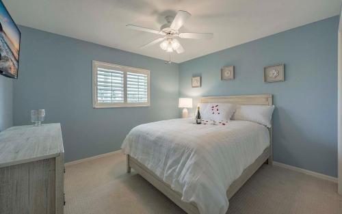 ein blaues Schlafzimmer mit einem Bett und einem Deckenventilator in der Unterkunft Flip & Flops - Amazing location with Boating Acces in Matlacha