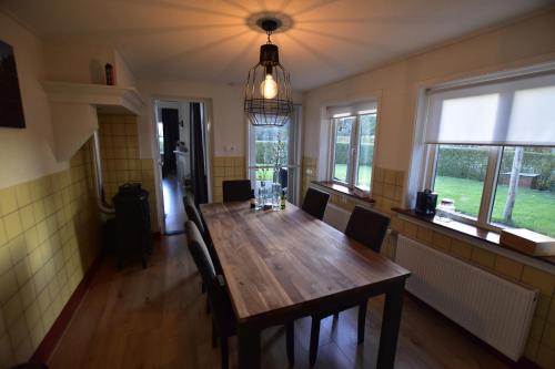 a dining room with a wooden table and chairs at The Holidayhouse - 5 min Efteling - max 5 pers & 1 baby in Loon op Zand