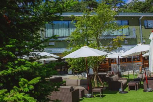 a patio with chairs and umbrellas in front of a building at 那須パラダイスヴィレッジ Hotel PARADISO in Nasushiobara