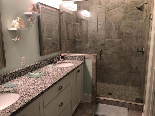 a bathroom with two sinks and a shower at Honu Kai in Jekyll Island