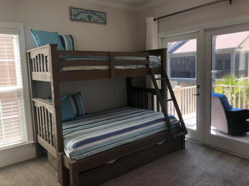 a bunk bed in a room with a balcony at Honu Kai in Jekyll Island