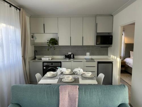 a kitchen with a table and a dining room at Peaceful and Luxurious Hidden Cove in Gqeberha