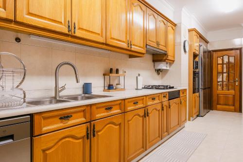 a kitchen with wooden cabinets and a sink at Vistoso Alto Palace in Lisbon