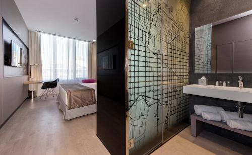 La salle de bains est pourvue d'un lavabo et d'un lit dans la chambre. dans l'établissement Negresco Princess 4* Sup, à Barcelone