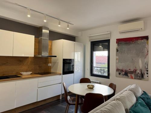 Una cocina con una mesa y un comedor. en Linea Apartment, en Belgrado