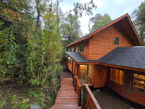 Cette maison en bois est accessible par un escalier. dans l'établissement Casa Mágica en Bosque Huilo Huilo, à Neltume