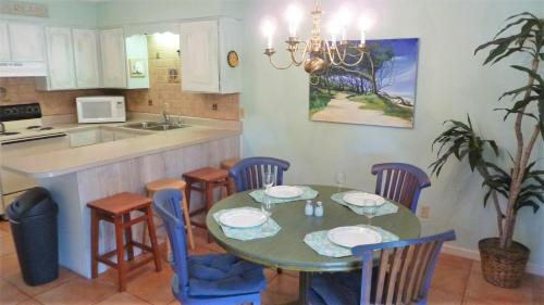 a kitchen with a table and chairs and a kitchen with a sink at Ariel West Duplex in Jekyll Island