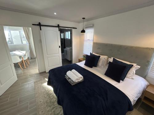 a bedroom with a large bed with two towels on it at Peaceful and Luxurious Hidden Cove in Gqeberha
