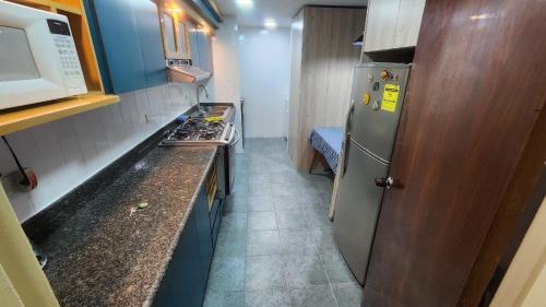 Il comprend une petite cuisine équipée d'un réfrigérateur et d'un comptoir. dans l'établissement Beautiful apartment in the colonial area of Chacao, à Caracas