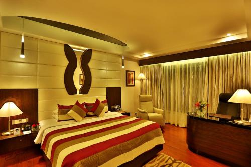 a hotel room with a bed and a television at Olive Downtown in Cochin