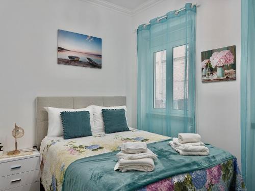 a bedroom with a bed with towels on it at Nazaré Stay Home - Alecrim T2 in Nazaré