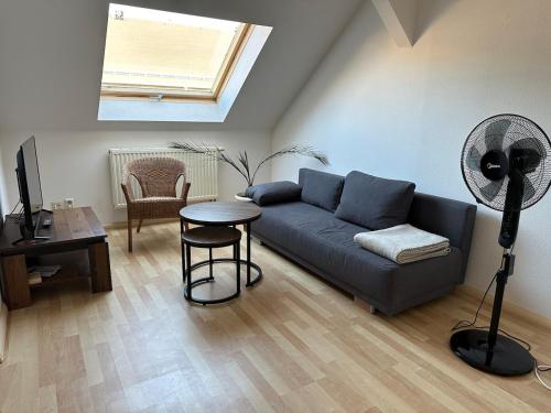 a living room with a blue couch and a table at 64qm für 3 Personen in Niederdorla