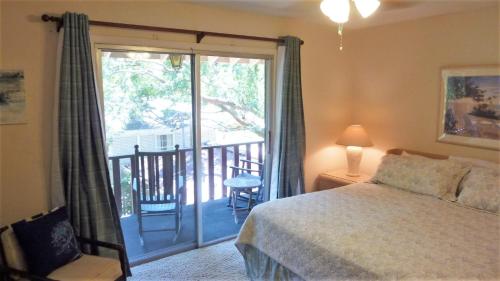 a bedroom with a bed and a balcony at Ariel East Duplex in Jekyll Island