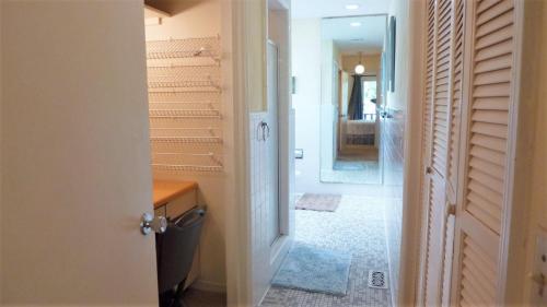 a bathroom with a door open to a hallway with stairs at Ariel East Duplex in Jekyll Island