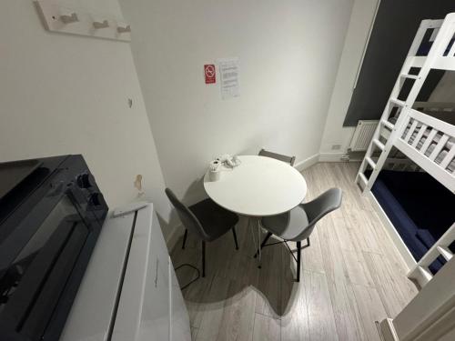 a white table and chairs in a room with a bunk bed at Trio Den in Zone 2 - Willesden Green in London