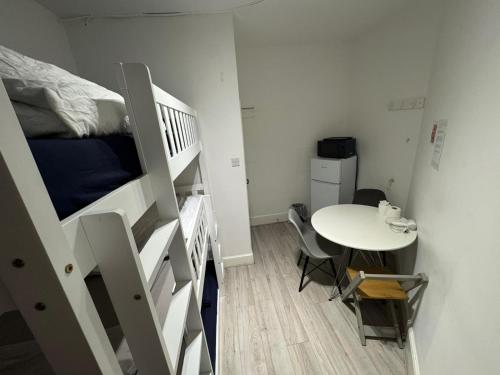 a small room with a bunk bed and a table at Trio Den in Zone 2 - Willesden Green in London