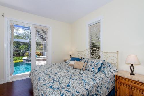 ein Schlafzimmer mit einem Bett und Blick auf einen Pool in der Unterkunft Key-Wester- Pool & Jacuzzi gated Community in Bonita Springs