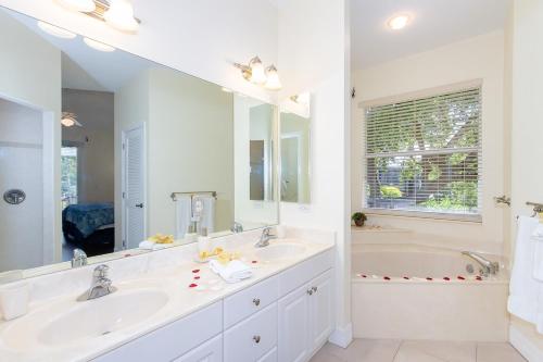 ein weißes Badezimmer mit zwei Waschbecken und einer Badewanne in der Unterkunft Key-Wester- Pool & Jacuzzi gated Community in Bonita Springs