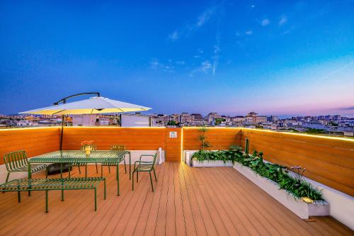 a deck with a table and chairs and an umbrella at Sky Garden Osmanthus Hostel - Drum & Bell City Center in Xi'an