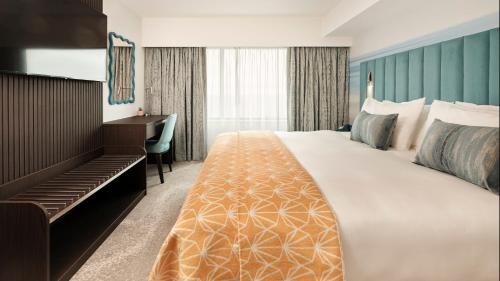 um quarto de hotel com uma cama grande e uma escrivaninha em Hotel Indigo Torquay, By IHG em Torquay