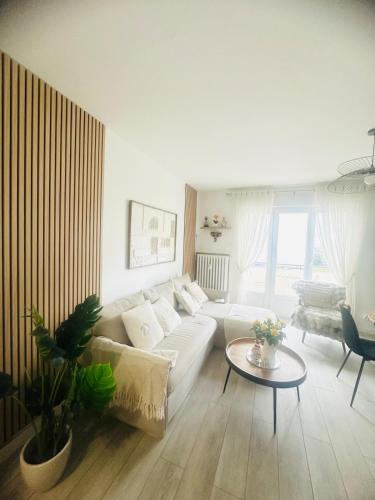 un salon avec un canapé blanc et une table dans l'établissement Charming Apartment, à Strasbourg