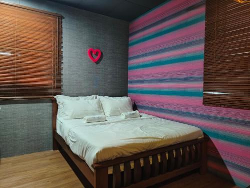 Ce lit se trouve dans un dortoir doté d'un cœur sur le mur. dans l'établissement SECRET STUDIO On Factory, à George Town