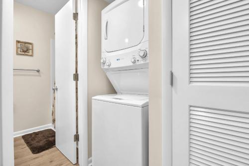 een witte wasruimte met een wasmachine en droger bij Beechouse in Caswell Beach