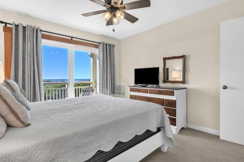 een slaapkamer met een bed, een tv en een raam bij Beechouse in Caswell Beach