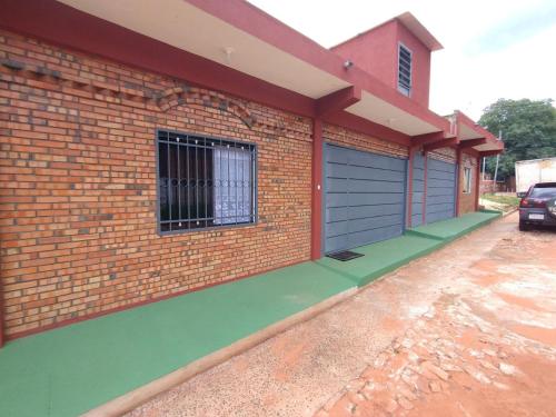 un edificio de ladrillo con una puerta azul y una ventana en Prisma21, en Luque