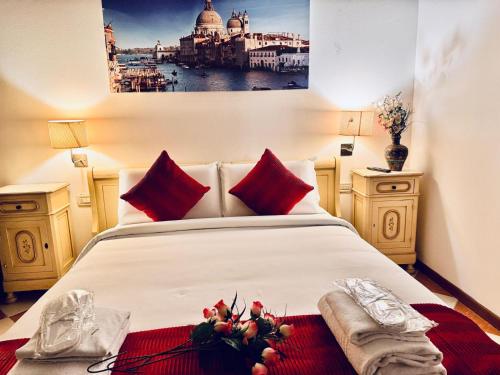 a bedroom with a large white bed with red pillows at Hotel Henry Venice in Venice