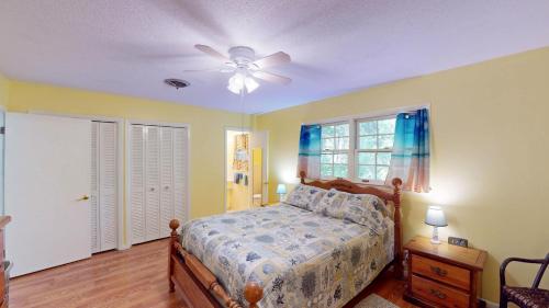 een slaapkamer met een bed en een plafondventilator bij A Hidde Gem Duplex in Jekyll Island