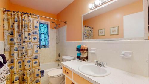 een badkamer met een wastafel, een toilet en een douche bij A Hidde Gem Duplex in Jekyll Island