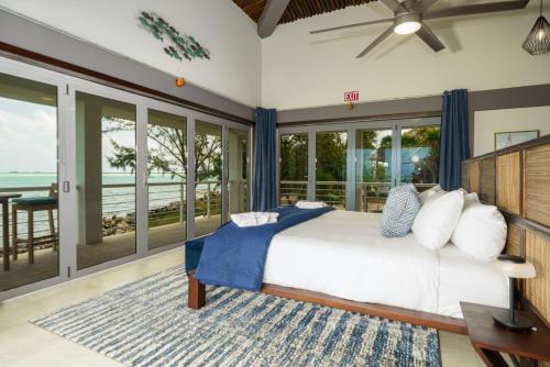 a bedroom with a bed with a view of the ocean at Luxury All-Inclusive Prince Private Island in San Pedro Island