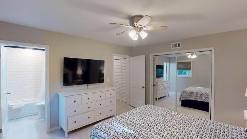 a bedroom with a bed and a flat screen tv at Sea Haven Duplex A in Jekyll Island